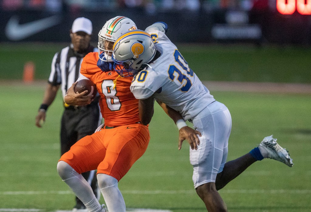 Jeremy Moussa of the FAMU Rattlers is tackled by Stephan Pierre of Albany State.